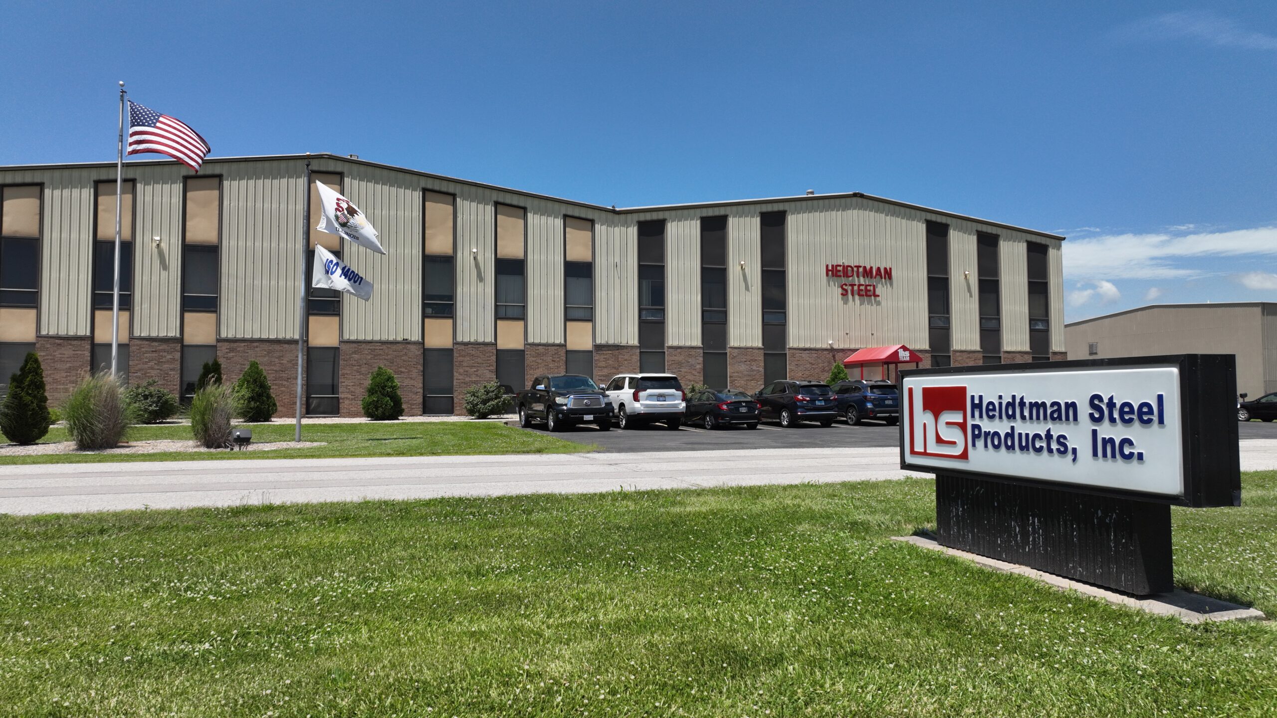 Exterior of Heidtman Steel Granite City facility with sign and flags.